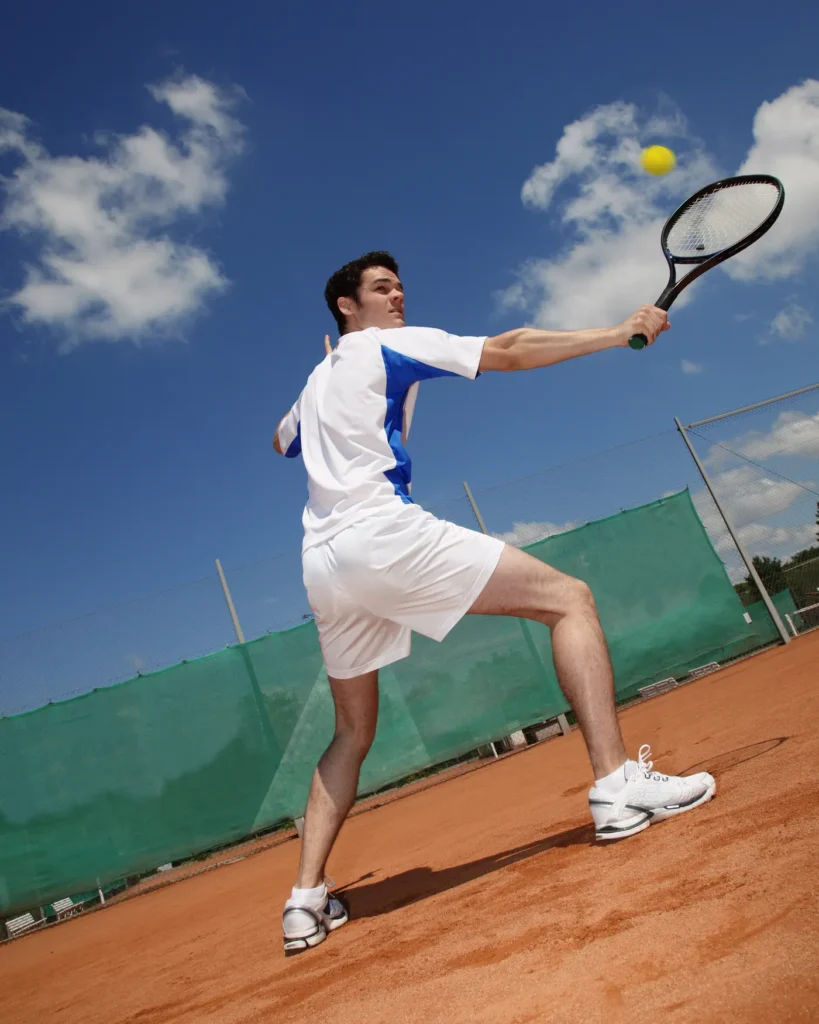 Player serving under a cloudy sky on a clay court