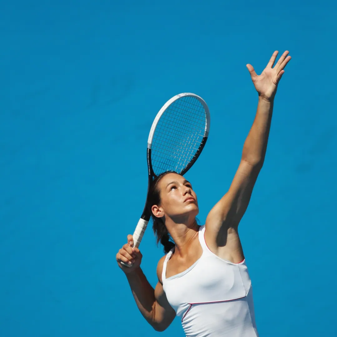 Woman tossing the ball to serve