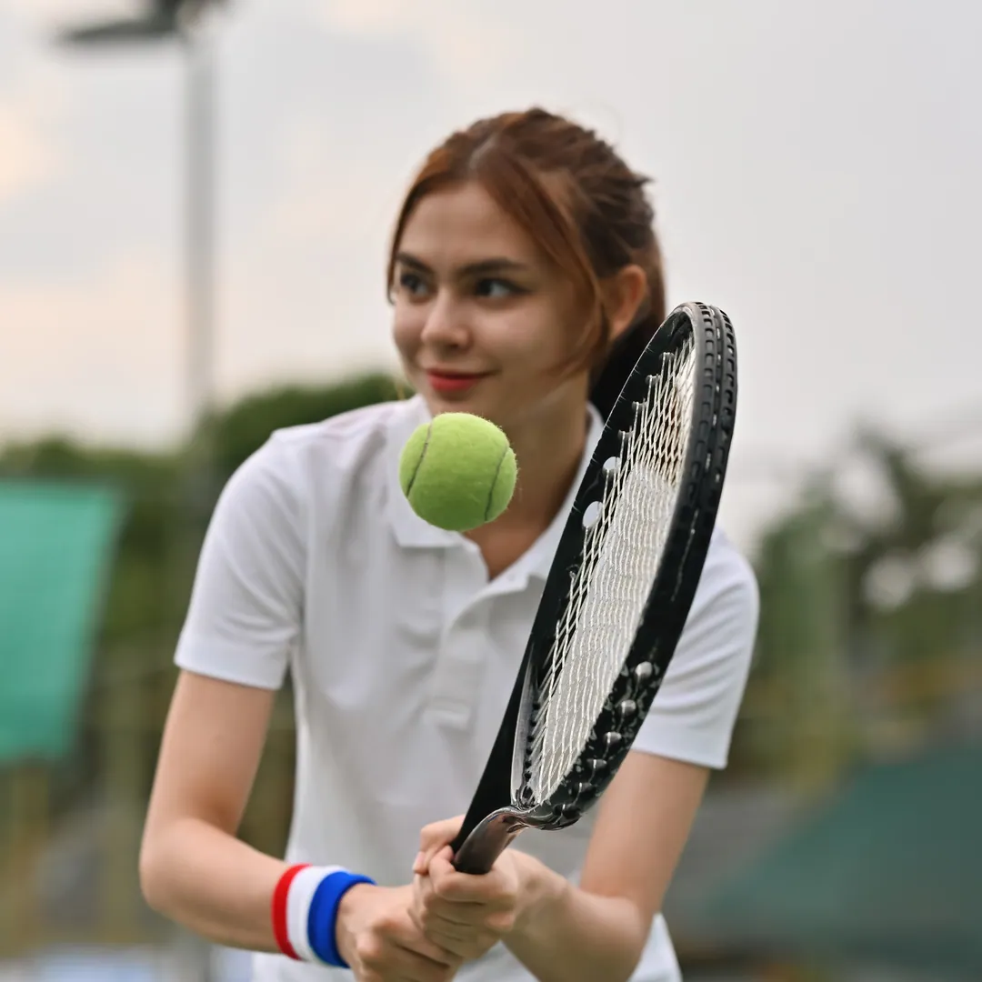 Woman watching the ball onto her racquet